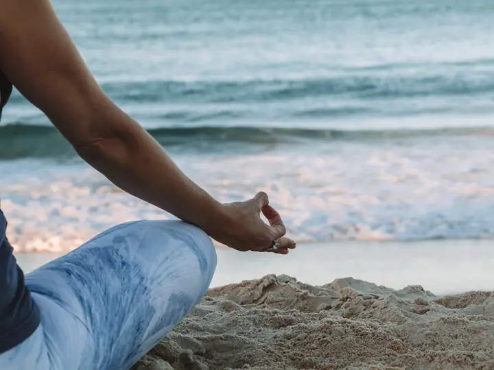 Persona meditando frente al mar